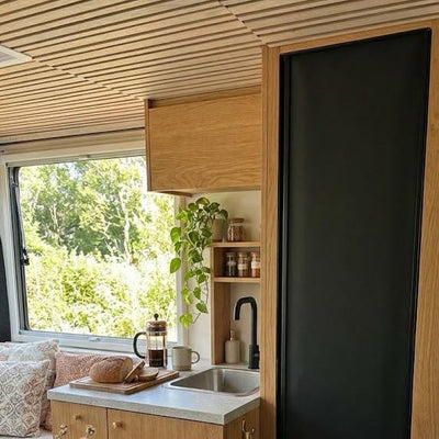 a kitchen with a black refrigerator and a window