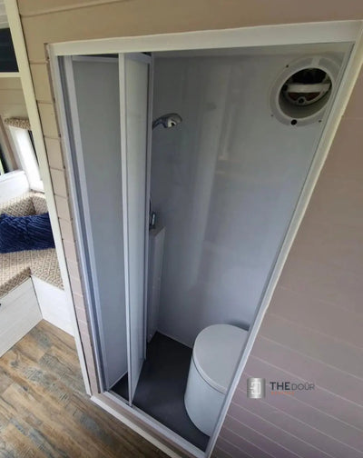 Porte de douche en acrylique blanc givré avec cadre en aluminium pliant bi-fold FOLdoûr conçue pour un camping-car FOLdoûr
